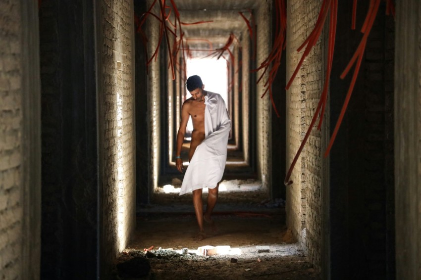 man with white towel walking on hallway