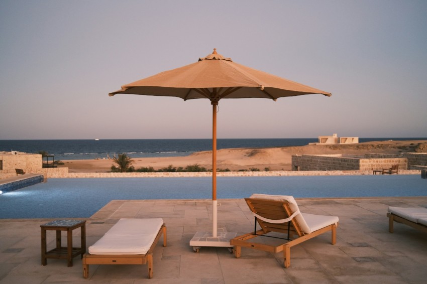 two lounge chairs and an umbrella on a patio