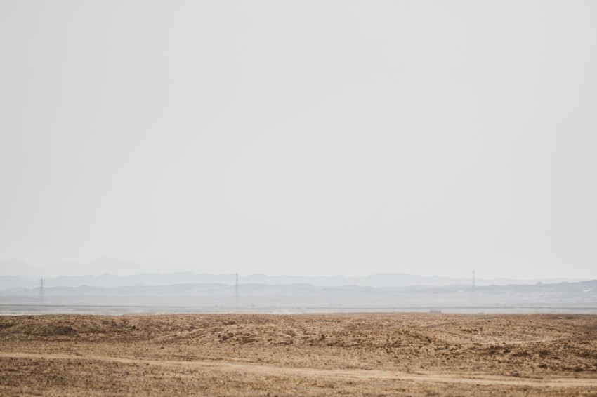 a large field with a body of water in the distance