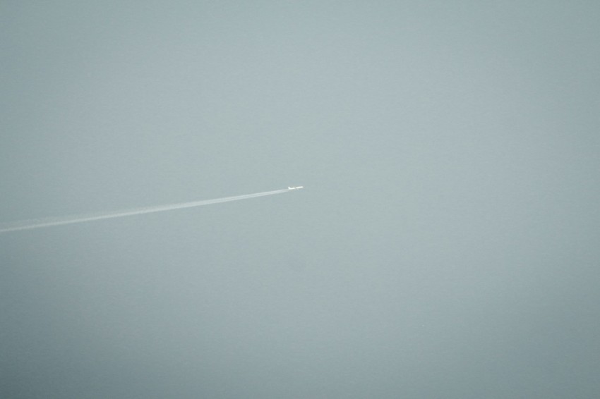 an airplane flying in the sky on a foggy day