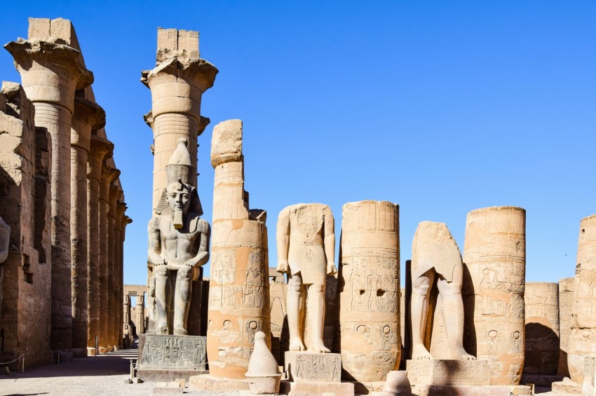 a group of statues in front of a blue sky