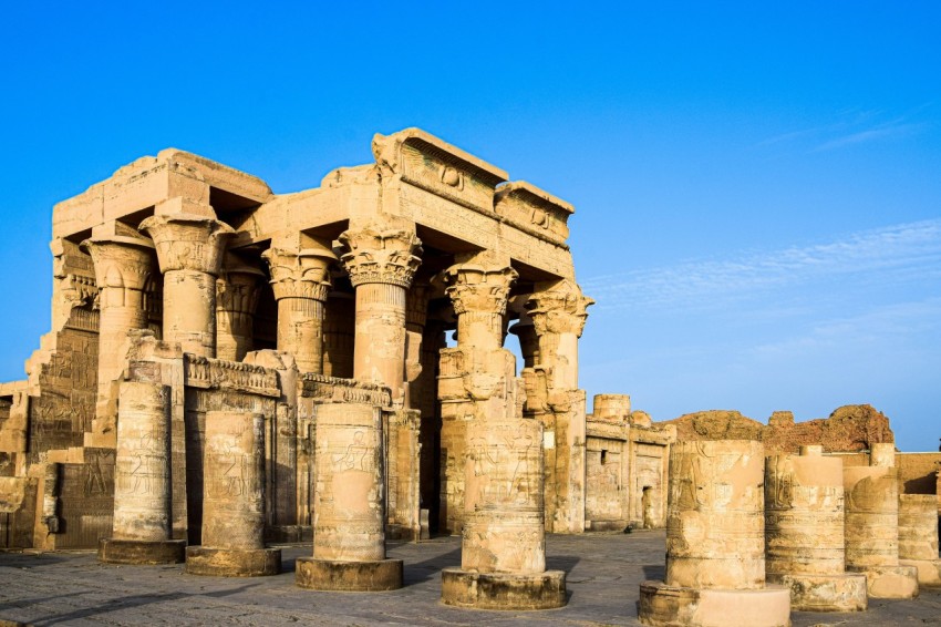 a group of stone pillars in front of a blue sky