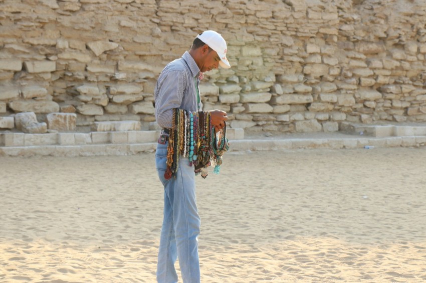 man in white thobe standing on sand during daytime