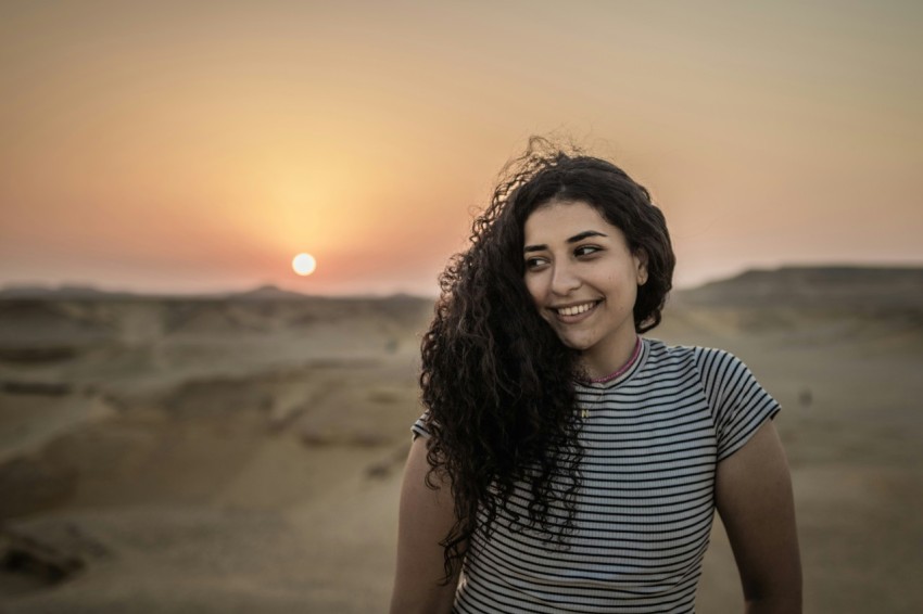 a woman standing in the middle of a desert