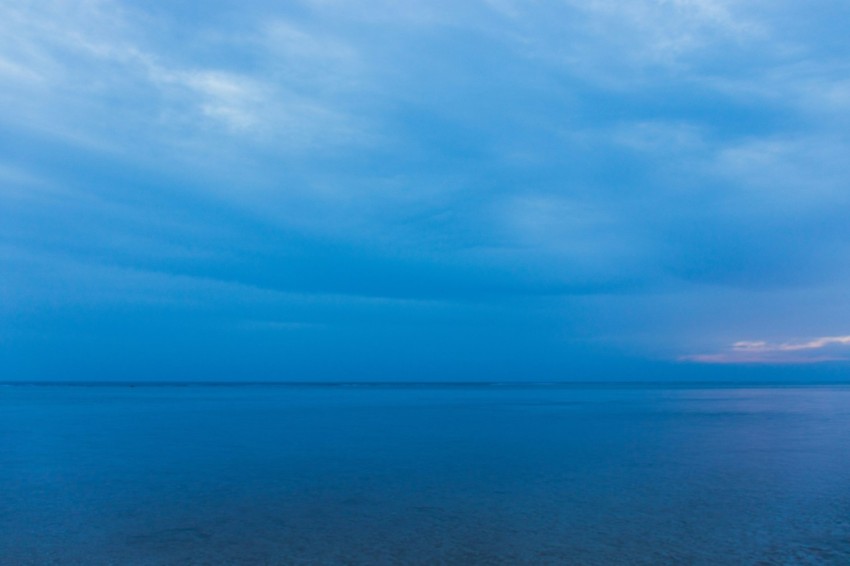 a large body of water under a cloudy sky