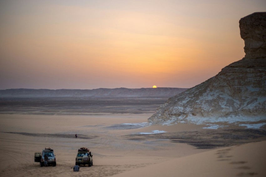 a couple of trucks that are sitting in the sand