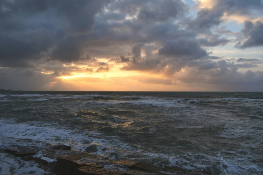 a large body of water under a cloudy sky