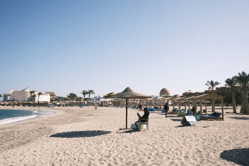 a sandy beach with umbrellas and lounge chairs