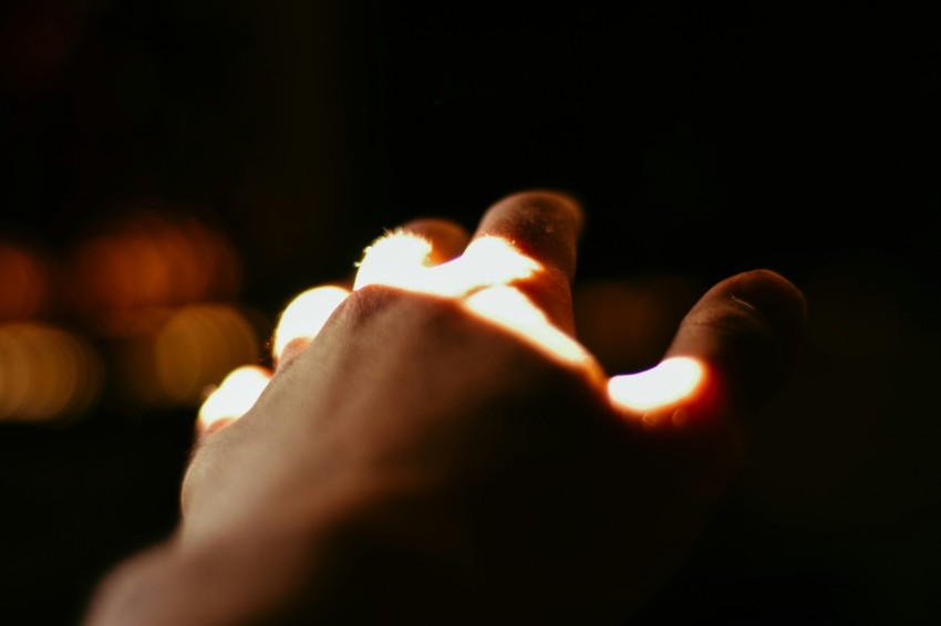 a person holding a lit candle in their hand