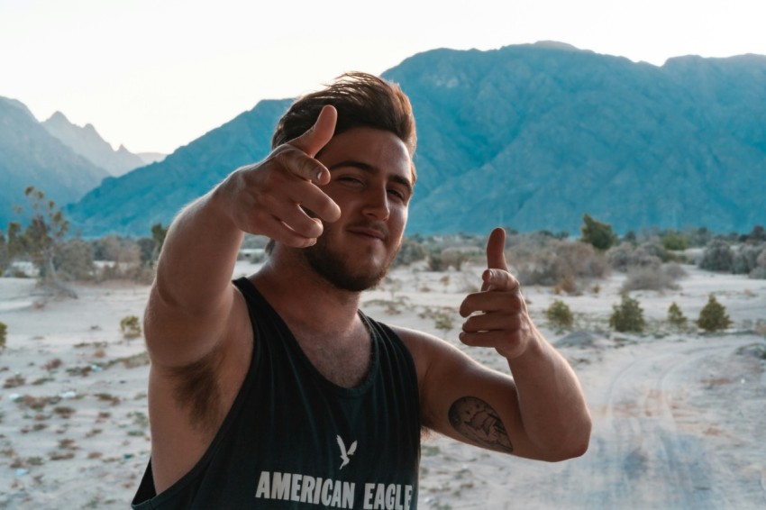 man in black tank top showing thumbs up sign