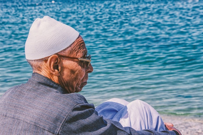 man sitting on beach during daytime