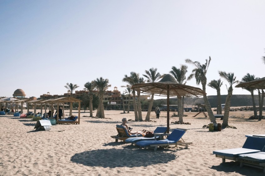 a sandy beach with lounge chairs and umbrellas