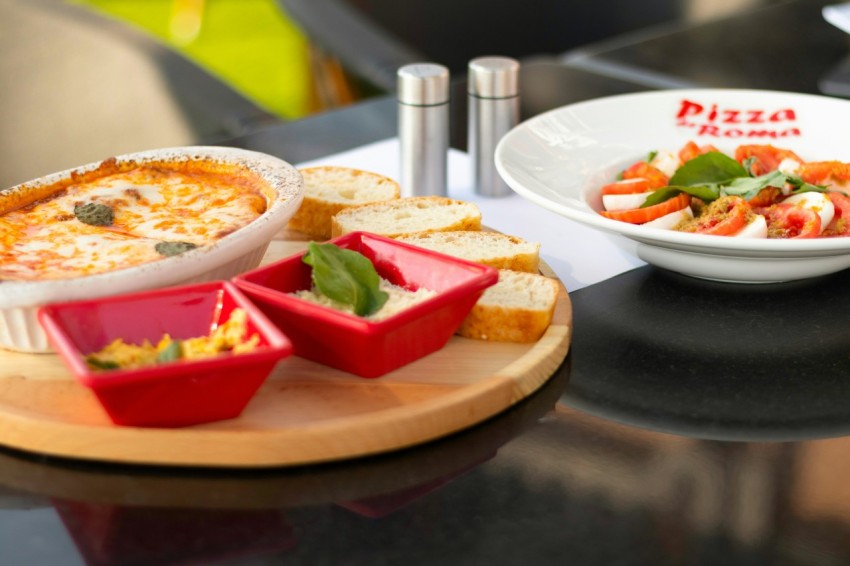 a plate of pizza and a bowl of salad on a table