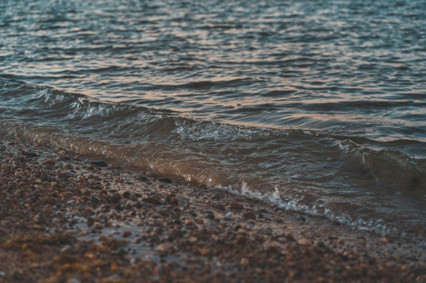 water waves on brown sand during daytime