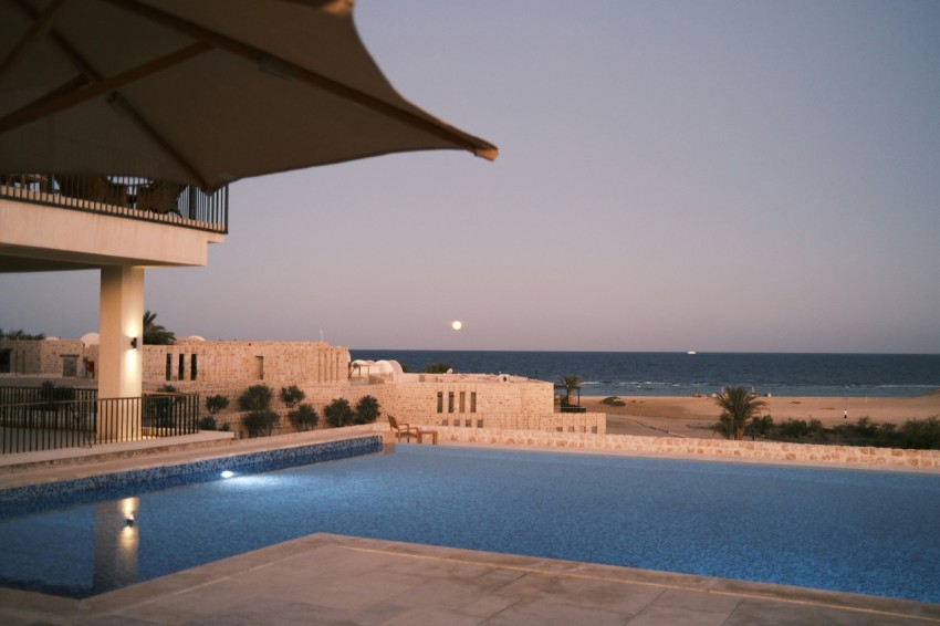 a large swimming pool next to a beach