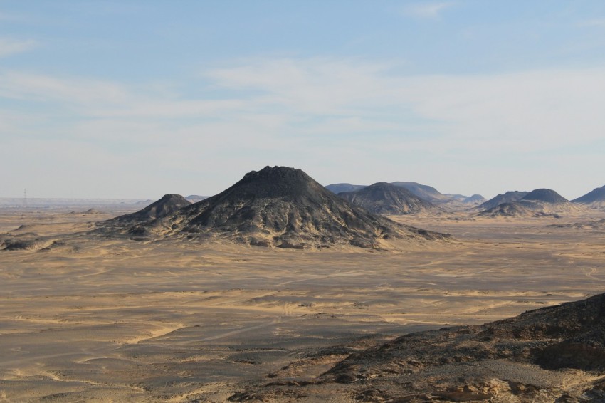 a desert landscape with a mountain in the distance