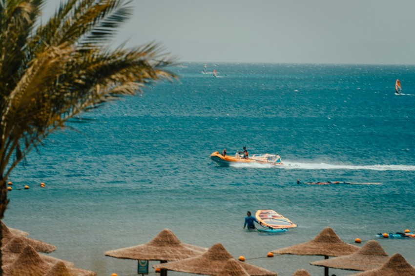 a group of people in a boat on the beach 5V0UXq