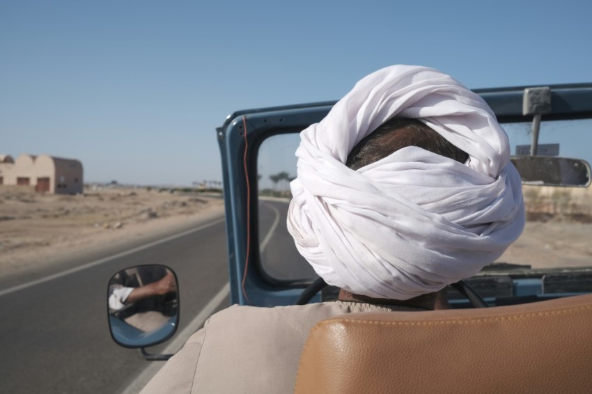 a man in a turban drives down the road