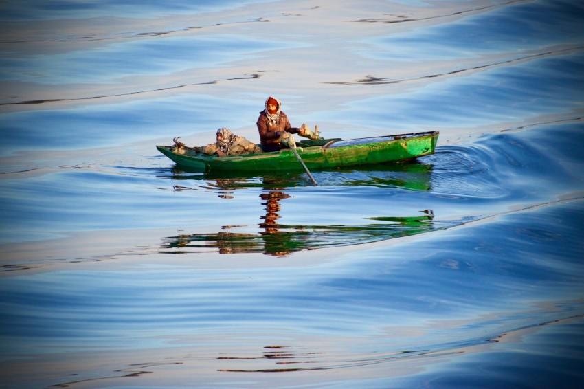 person riding green boat zdkzFO