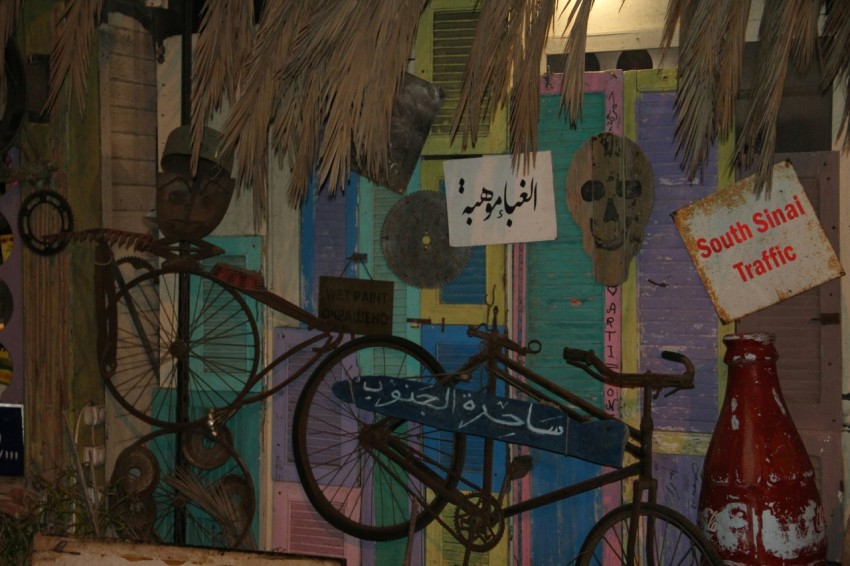 a bike parked next to a wall covered in signs 1y