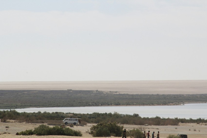 a group of people standing on top of a sandy beach