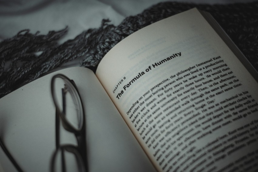 an open book with a pair of glasses on top of it