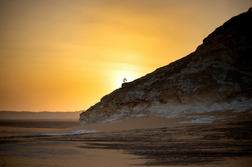 a person standing on top of a sandy beach