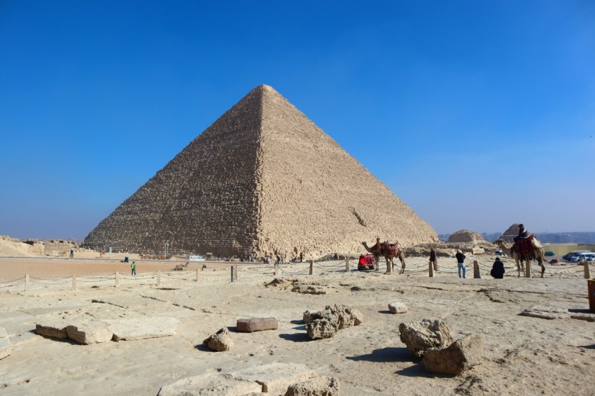 a group of people standing in front of a pyramid