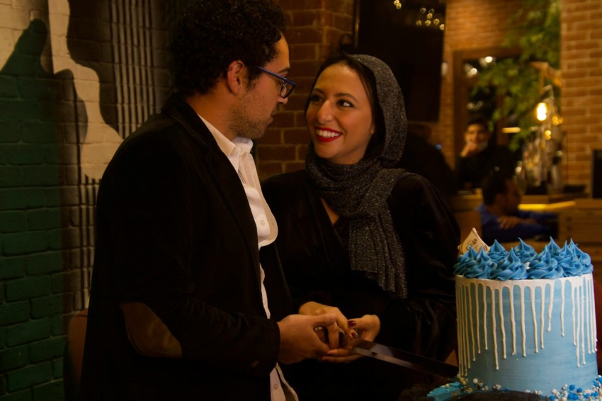 a man and woman cutting a cake together