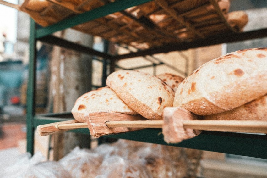 a bunch of loaves of bread sitting on a rack