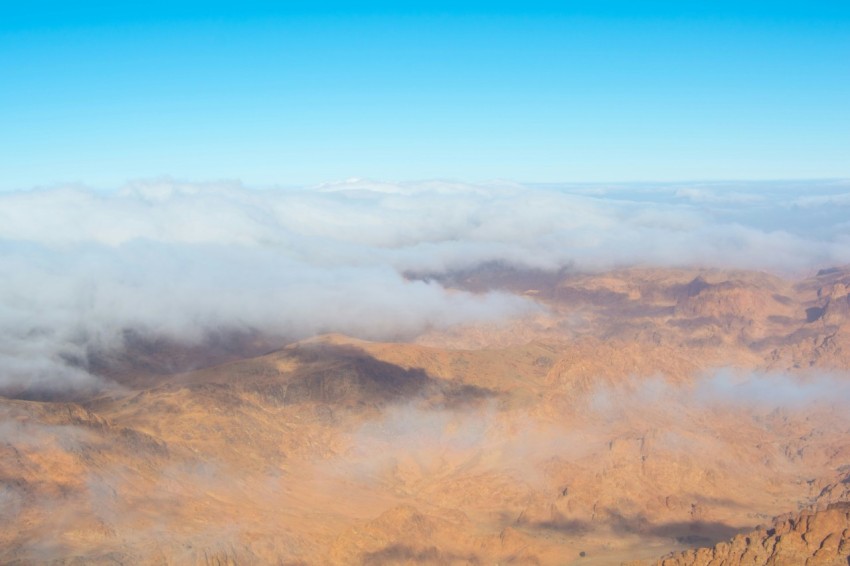 a view of the mountains and clouds from a plane