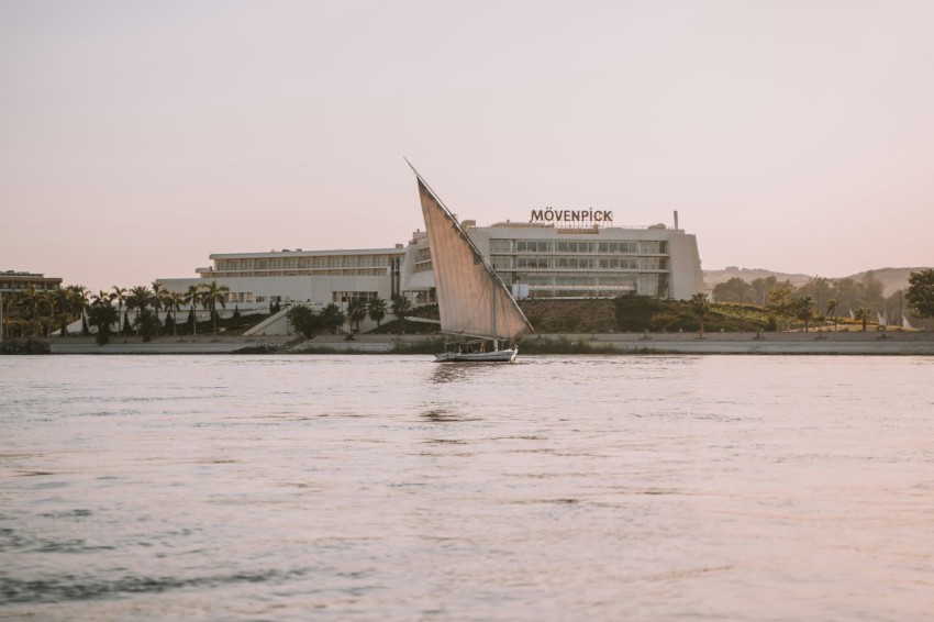 a sailboat on a body of water in front of a hotel