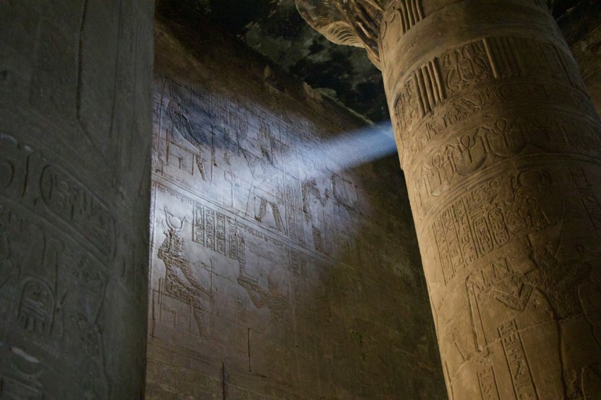 a light shines on the wall of a temple