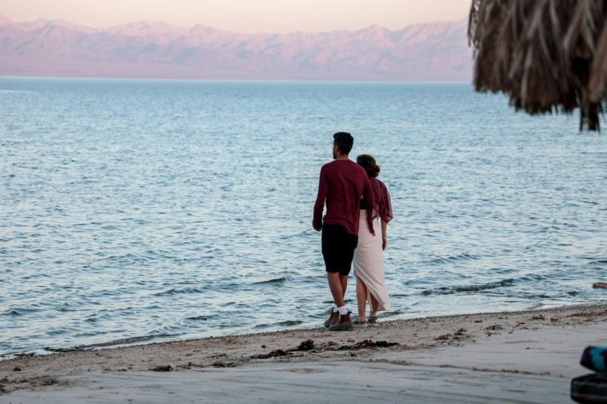 male and female standing on beach