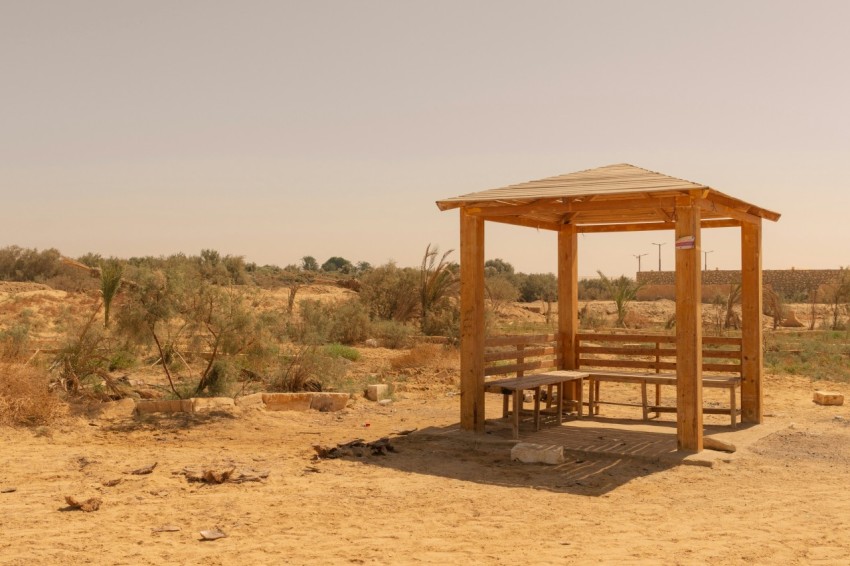 a wooden shelter in the middle of a desert