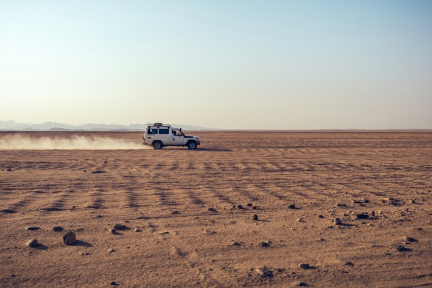 white suv on brown sand during daytime