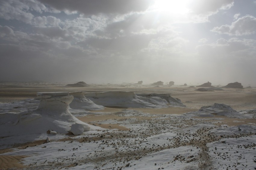 the sun shines through the clouds over the desert