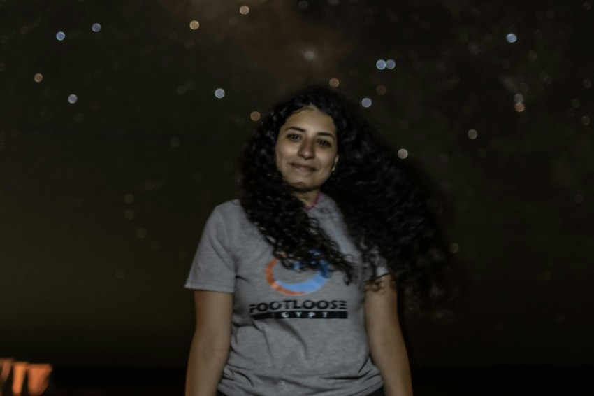 a woman standing in front of a sky full of stars