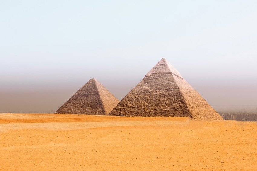 a group of three pyramids in the desert