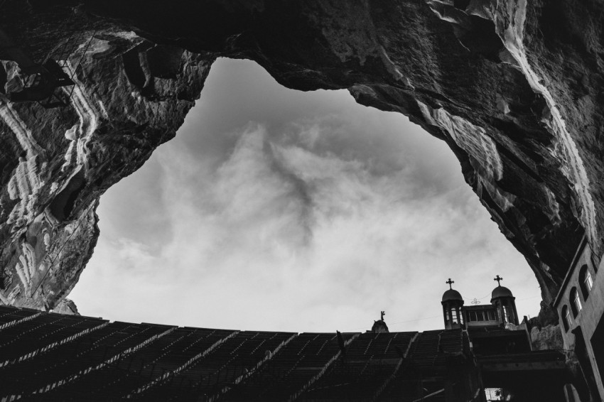 a black and white photo of a church in a cave