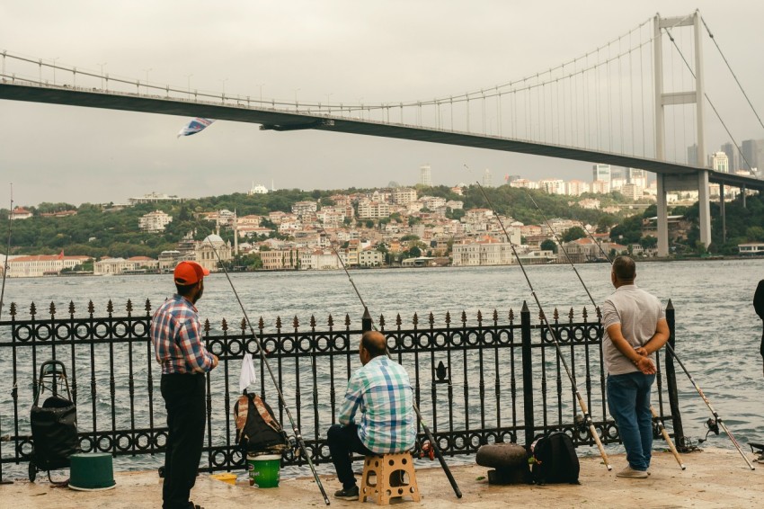 a group of people standing next to a body of water