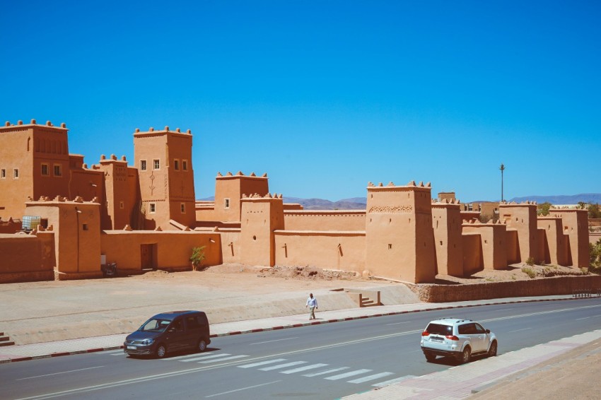 two cars passing near brown temple mCoYD