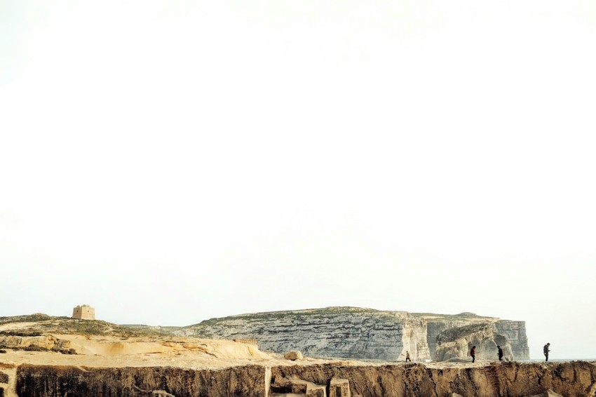 four persons standing on mountain