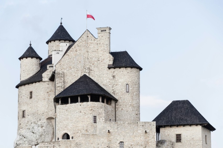 white and black castle with flag of poland