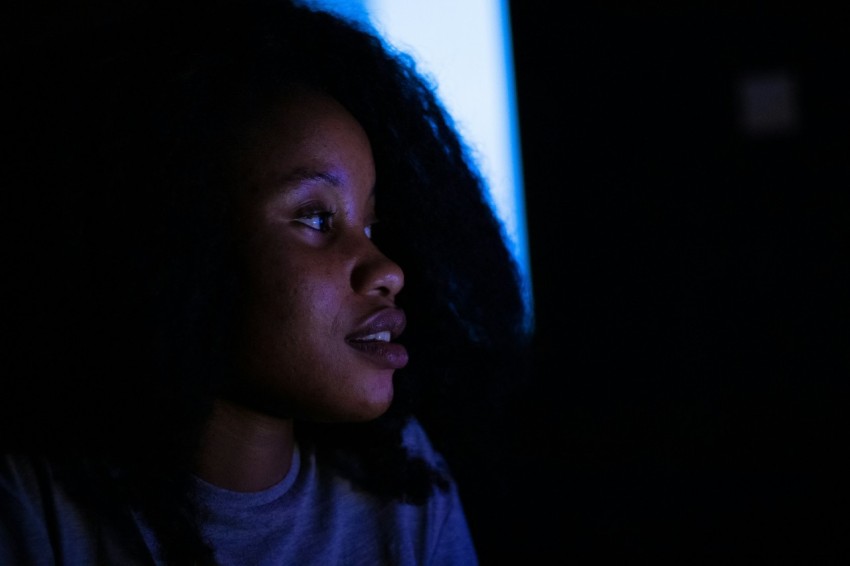 a woman in a dark room staring at something