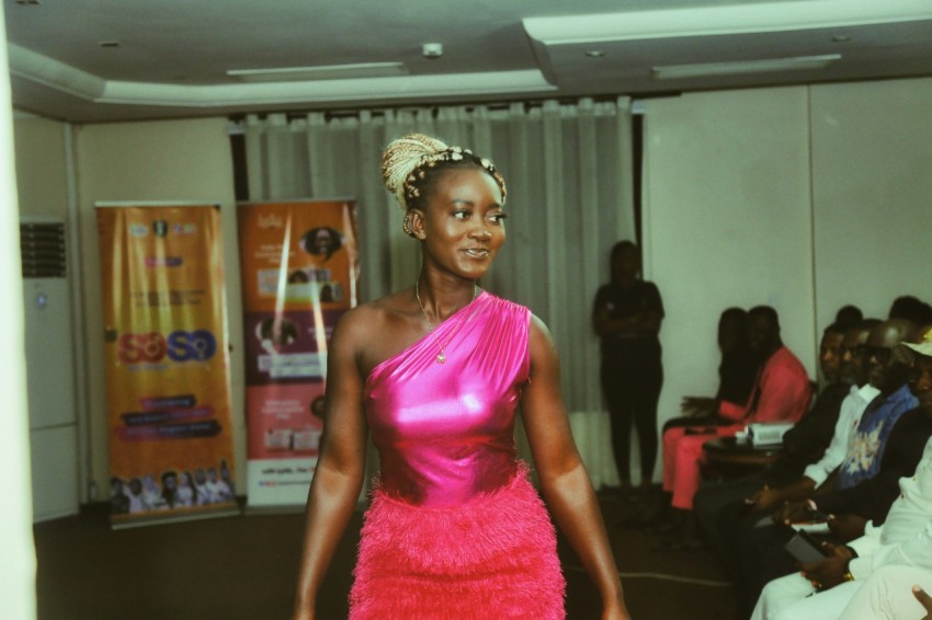 a woman in a pink dress walking down a runway