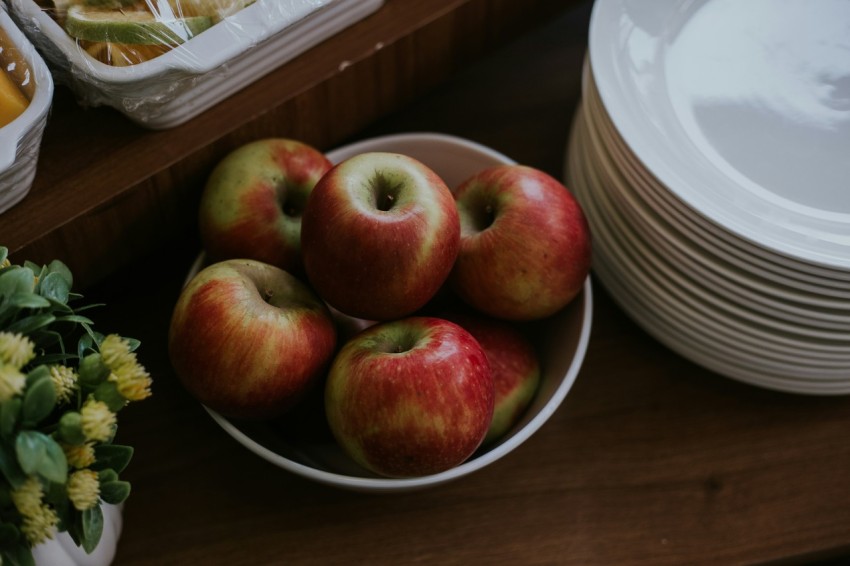 red apples on white ceramic bowl