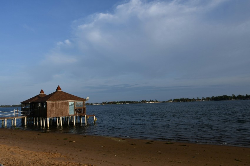 brown wooden house on sea shore during daytime