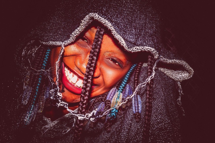 a smiling woman with braids on her head