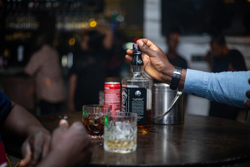 a person pouring a drink into a glass